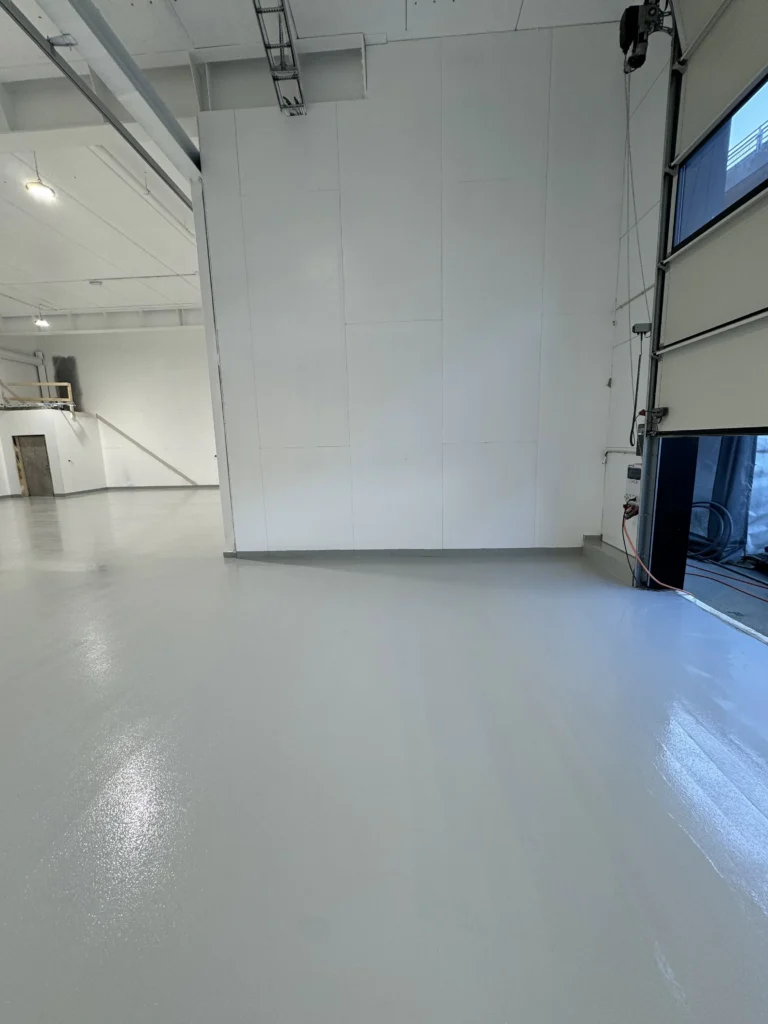 Tett og glatt betonggulv i industrihall, nylig ferdigstilt prosjekt.