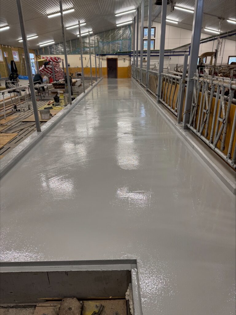 Høyglansert betonggulv i industrilokale med maskiner og arbeidsområde.