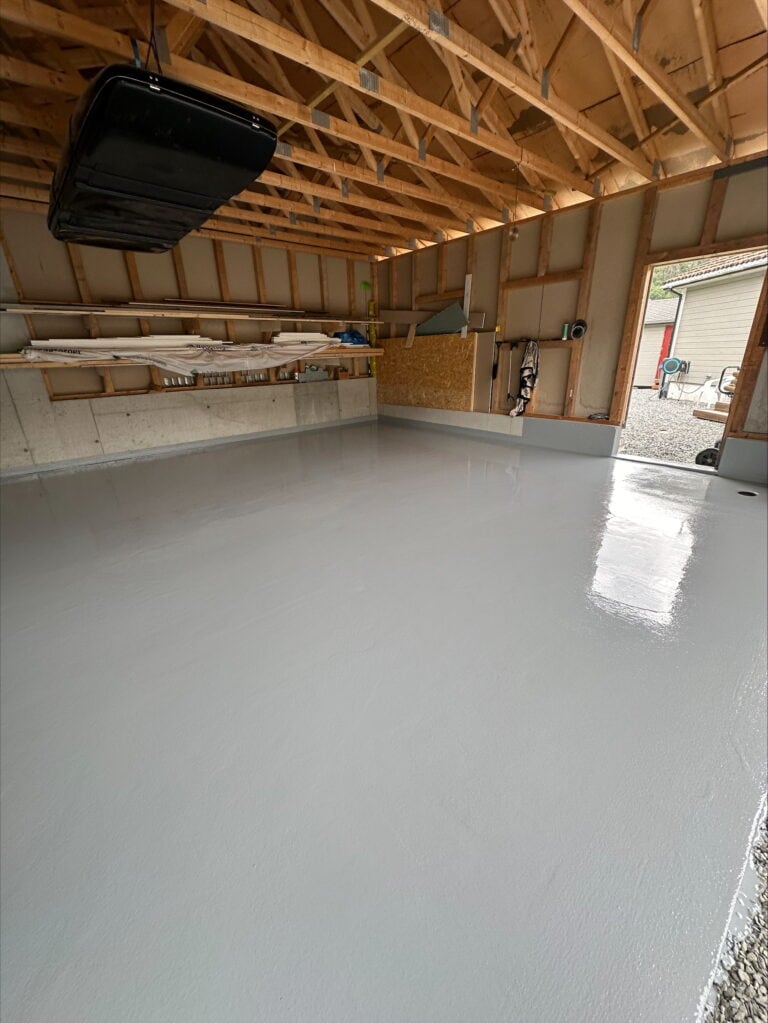 Nytt betonggulv med glatt overflate i garasjen under bygging.