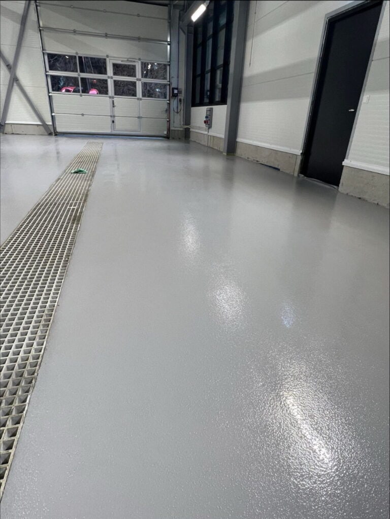 Epoxybelagt gulv i industrilokale med glatt overflate og drenering.