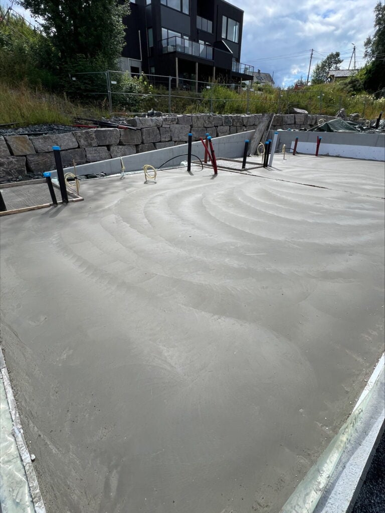 Betongplate med armering og rørinstallasjoner for basseng.