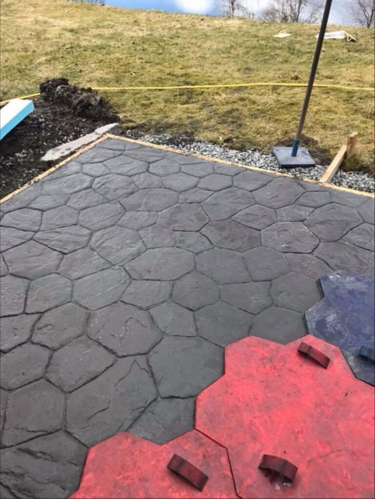 Uteområde med ny støpt og avrettet belegningsstein og kantstein.