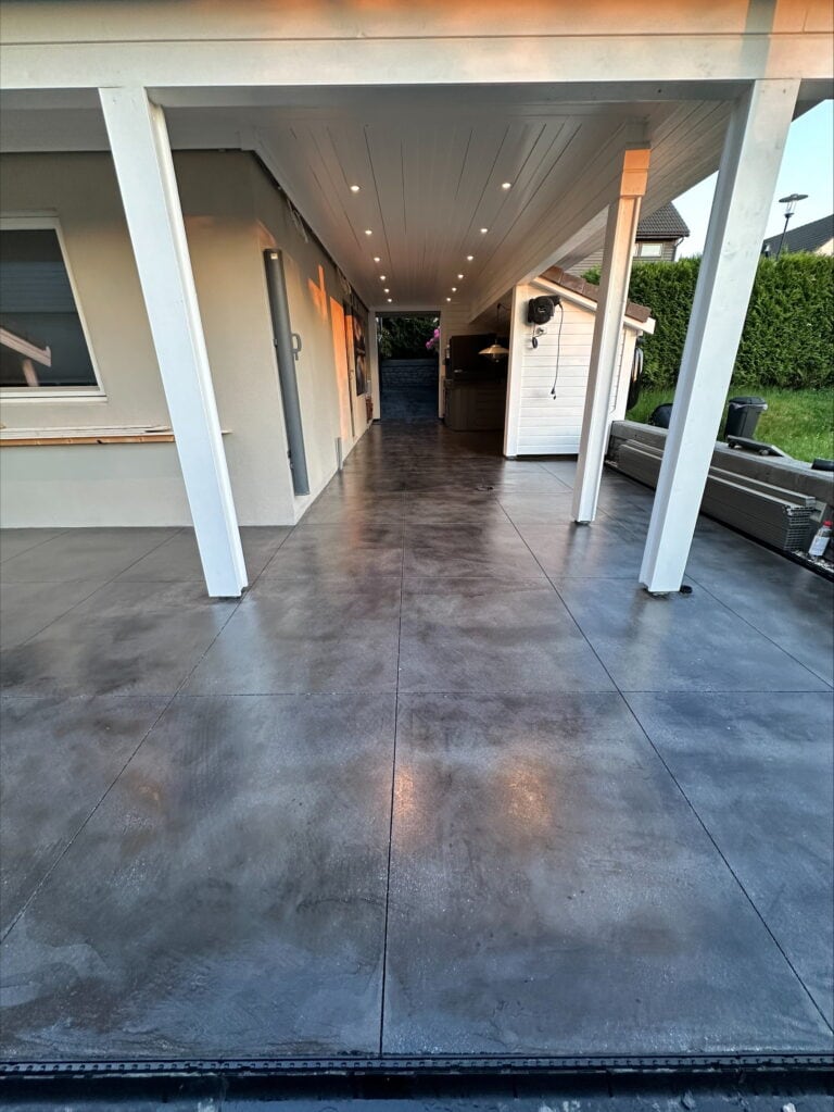 Utendørs betonggulv med glatt, polert overflate under tak, tilpasset terrasse eller uteområde.
